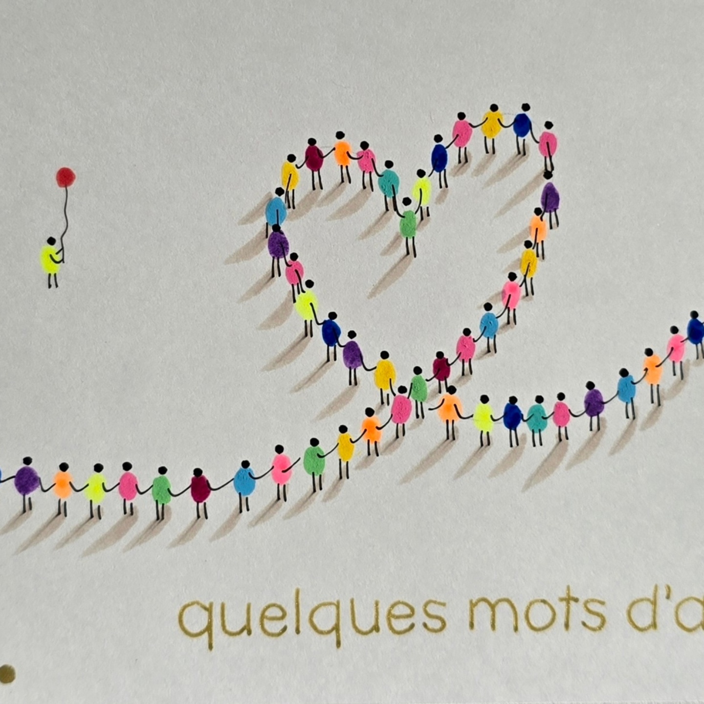 Un cœur composé de petits personnages multicolores qui se tiennent la main, avec leurs ombres dessinées sur le papier